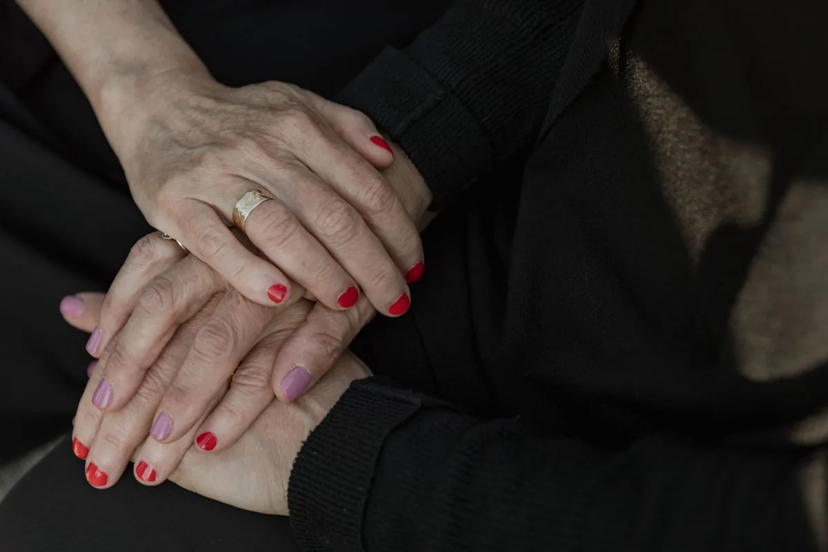 Two people holding hands in comfort and support